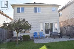 Rear exterior featuring light-colored siding and a dark shingle roof - 