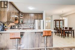 Kitchen featuring wood-finish cabinetry, stainless steel appliances, and a mosaic tile backsplash - 