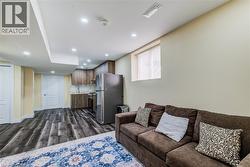 Full kitchen featuring wood-finish cabinetry, stainless steel appliances, and a tile backsplash - 