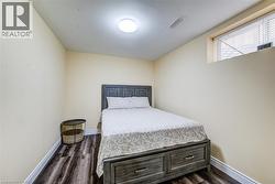 Recessed window with blinds, overhead lighting, and wood-finish flooring - 