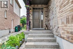 Stone aggregate steps leading to a recessed entry with a dark panel door and sidelight - 