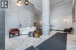Lobby interior featuring large format marble-look flooring and a prominent exposed concrete column - 