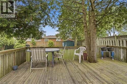 Spacious wooden deck with a built-in tree feature, complete with sturdy railing and a latticework fence - 834 Mohawk Road E, Hamilton, ON - Outdoor With Deck Patio Veranda With Exterior