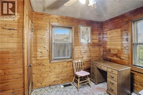 Paneled room featuring wood-finish walls, a window with blinds, and ceiling-mounted lighting - 834 Mohawk Road E, Hamilton, ON - Indoor