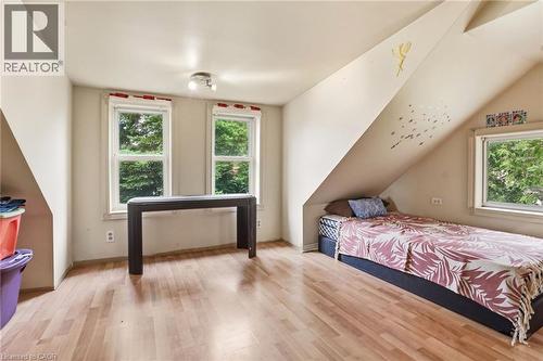 Attic space featuring wood-finish flooring, multiple windows, and angled ceilings - 834 Mohawk Road E, Hamilton, ON - Indoor Photo Showing Bedroom