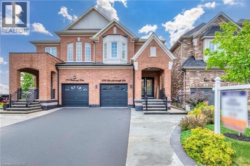 Brick facade residence featuring a two-car garage, bay window, and arched entryways - 598 Bessborough Drive, Milton, ON - Outdoor With Facade