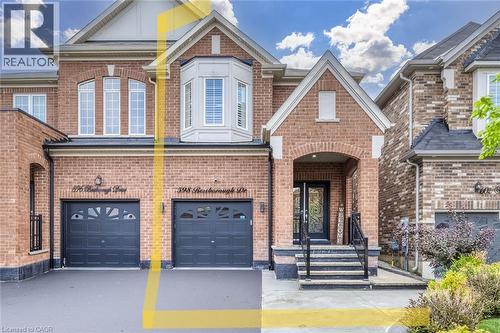 Brick facade residence featuring an arched portico, dual garage doors, and a bay window - 598 Bessborough Drive, Milton, ON - Outdoor With Facade