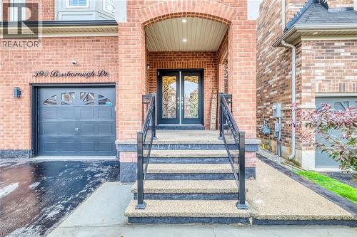 Brick facade entrance featuring double glass-insert doors and an arched portico - 598 Bessborough Drive, Milton, ON - Outdoor