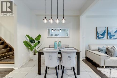 Dining area featuring recessed lighting, a modern four-light pendant fixture, and light-toned tile flooring - 598 Bessborough Drive, Milton, ON - Indoor Photo Showing Dining Room