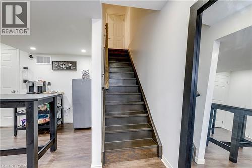 Staircase with dark wood-finish treads and risers, featuring a wood handrail and white wall trim - 598 Bessborough Drive, Milton, ON - Indoor Photo Showing Other Room