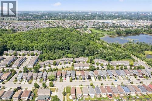 Aerial perspective showcasing a residential community bordered by mature trees and a natural water feature - 71 Peach Blossom Crescent, Kitchener, ON 