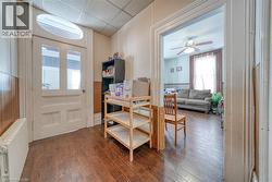 Foyer with radiator, a drop ceiling, dark wood-style flooring, and a wainscoted wall - 