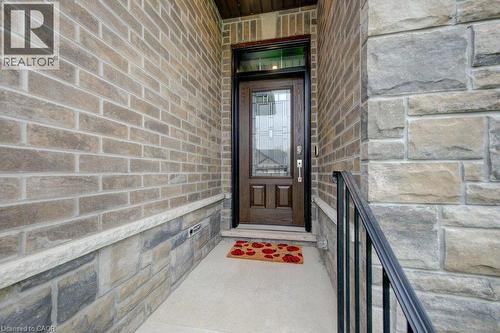 Entryway featuring a dark wood-finish door with decorative glass, concrete porch, and wrought iron railing - 15 Matheson Crescent, Innerkip, ON - Outdoor