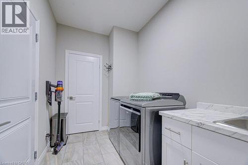 Dedicated laundry area featuring tile flooring and light gray walls - 15 Matheson Crescent, Innerkip, ON - Indoor Photo Showing Laundry Room