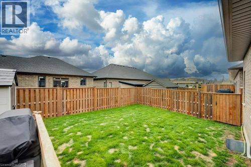 Private backyard featuring a wooden privacy fence, a well-maintained lawn, and a storage shed - 15 Matheson Crescent, Innerkip, ON - Outdoor