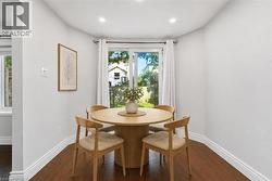 Virtually staged, Dining area featuring wood-finish flooring, white baseboards, and light-colored walls - 
