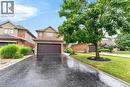 Brick and stone facade home featuring an integrated garage with a dark panel door - 43 Liam Drive, Ancaster, ON  - Outdoor 