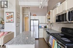 Functional Kitchen with Island and Stainless Steel Appliances - 