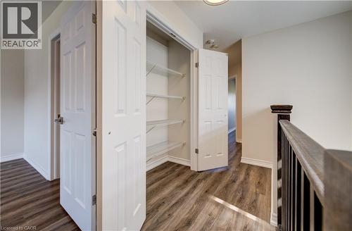 Hallway with wood-finish flooring featuring a built-in closet with bifold doors and wire shelving - 80 Miranda Path, Elmira, ON - Indoor Photo Showing Other Room