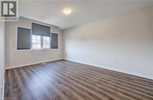 Spacious room featuring wood-finish flooring, white baseboards, and neutral wall paint - 80 Miranda Path, Elmira, ON - Indoor Photo Showing Other Room