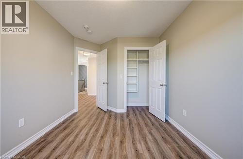 Interior room featuring wood-finish flooring, light neutral wall paint, and white baseboards - 80 Miranda Path, Elmira, ON - Indoor Photo Showing Other Room
