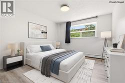 Bedroom featuring light wood-finish flooring and white walls - 