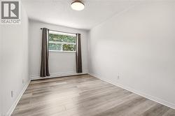 Room featuring light wood-finish flooring, white walls, and white trim - 