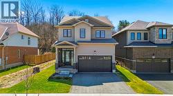 View of front of property featuring board and batten siding, asphalt driveway, a garage, and stone siding - 