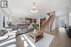 Living area with light wood-style floors and hanging lights - 