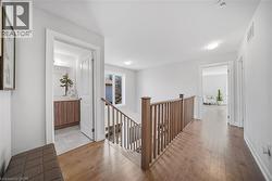 Hallway with an upstairs landing and light wood-type flooring - 