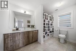 Full bath with vanity, a shower with curtain, and light tile patterned flooring - 