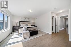 Bedroom featuring light wood-type flooring and baseboards - 