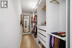 Walk in closet with light wood-style floors - 