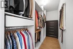 Walk in closet with light wood finished floors - 