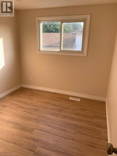 Interior room featuring wood-finish flooring, neutral wall paint, and white baseboards - 86 Belwood Crescent, Kitchener, ON - Indoor Photo Showing Other Room