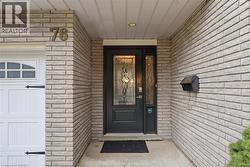 Front entry featuring a dark-paneled door with decorative leaded glass, a sidelight panel, and a recessed ceiling light - 
