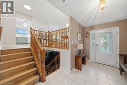 Entry foyer featuring tiled flooring, a white front door with decorative glass inserts, and a coordinating sidelight - 
