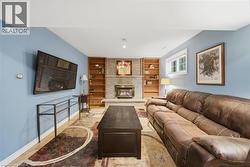 Living area featuring a gas fireplace with a light brick surround and hearth, flanked by built-in wood shelving - 