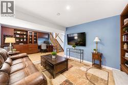 Finished basement featuring wood-finish flooring and light blue walls - 