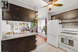 Kitchen featuring white appliances, dark cabinetry, and tile flooring - 