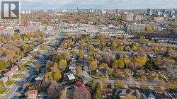 Aerial depiction of a residential neighborhood with tree-lined streets, single-story homes, and multi-story apartment buildings - 