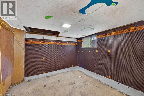 Basement space featuring dimpled membrane wall treatment, a small window, concrete flooring, and exposed ceiling joists - 23 Harrison Avenue, Hamilton, ON - Indoor Photo Showing Other Room