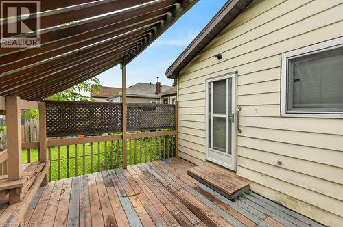 Spacious outdoor deck featuring slatted wood pergola, lattice privacy screen, and built-in wood bench - 23 Harrison Avenue, Hamilton, ON - Outdoor With Deck Patio Veranda With Exterior