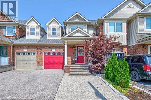 Brick and siding exterior featuring a bright red entry door and a covered front porch - 4057 Donnic Drive, Burlington, ON - Outdoor With Facade