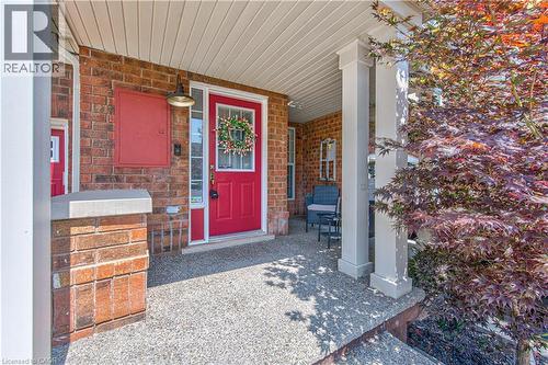 Inviting brick facade with a vibrant red front door, featuring a transom window and sidelights - 4057 Donnic Drive, Burlington, ON - Outdoor