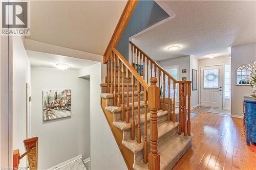 Carpeted staircase with light wood banister and spindles - 4057 Donnic Drive, Burlington, ON - Indoor Photo Showing Other Room