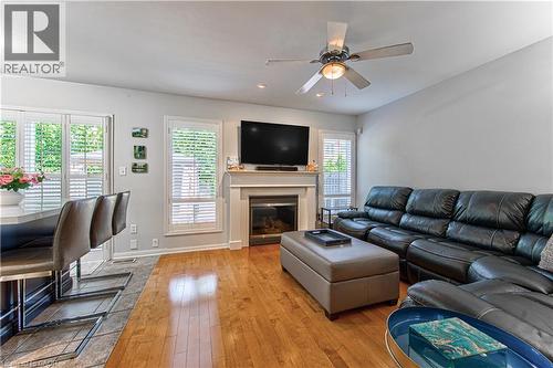 Living area featuring a fireplace with mantel, ceiling fan, and wood-finish flooring - 4057 Donnic Drive, Burlington, ON - Indoor Photo Showing Living Room With Fireplace