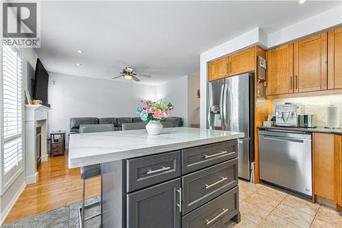 Kitchen island with a light-toned countertop, contrasting dark cabinetry, and integrated storage - 4057 Donnic Drive, Burlington, ON - Indoor Photo Showing Kitchen