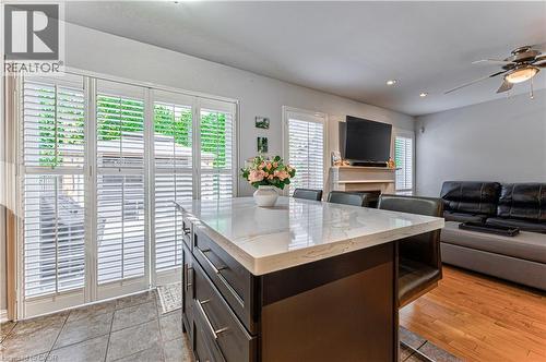 Kitchen island with a light-toned countertop and integrated seating, contrasting with dark base cabinetry - 4057 Donnic Drive, Burlington, ON - Indoor
