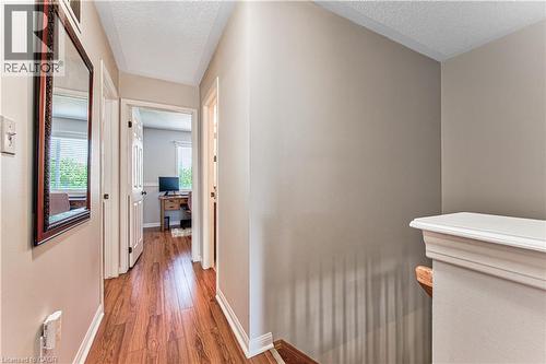 Hallway featuring rich wood-finish flooring, light neutral wall paint, and white trim molding - 4057 Donnic Drive, Burlington, ON - Indoor Photo Showing Other Room